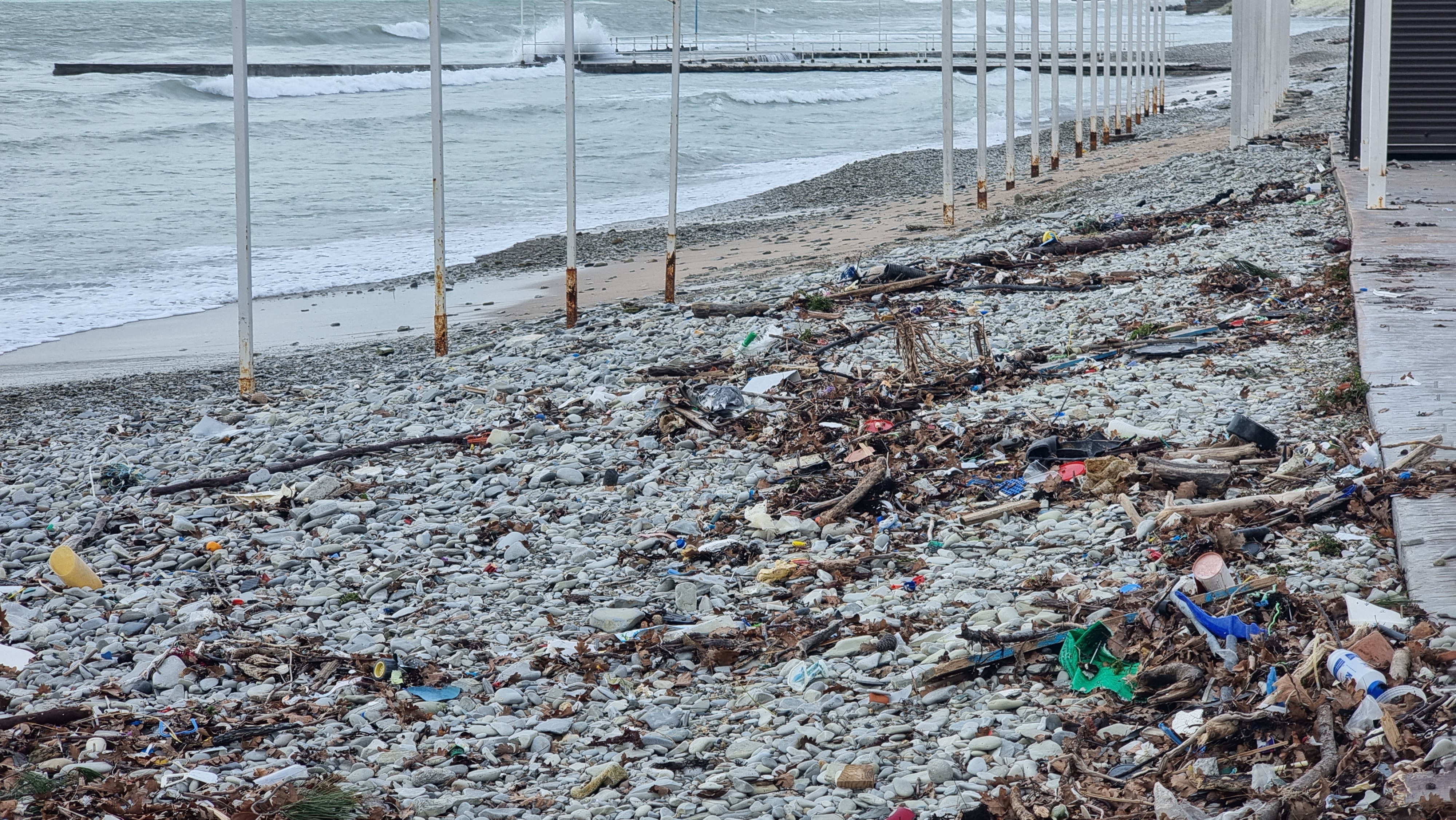 Пляж после шторма. Берег после шторма. Берег заваленный мусором.
