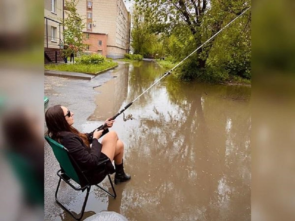 Ловить рыбу на затопленных улицах вышли жители в Таганроге после ливня днем 10 мая